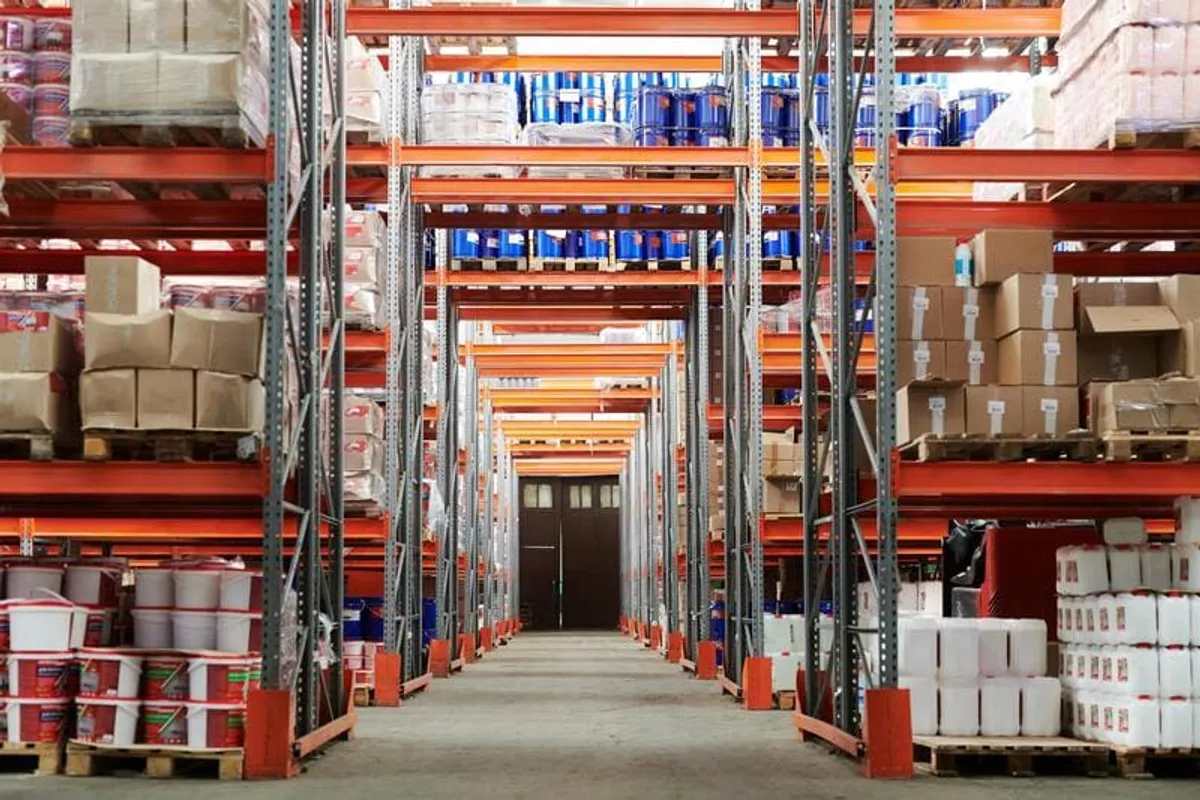 Almacén industrial con estanterías llenas de cajas y productos paletizados, típico de un negocio B2B
